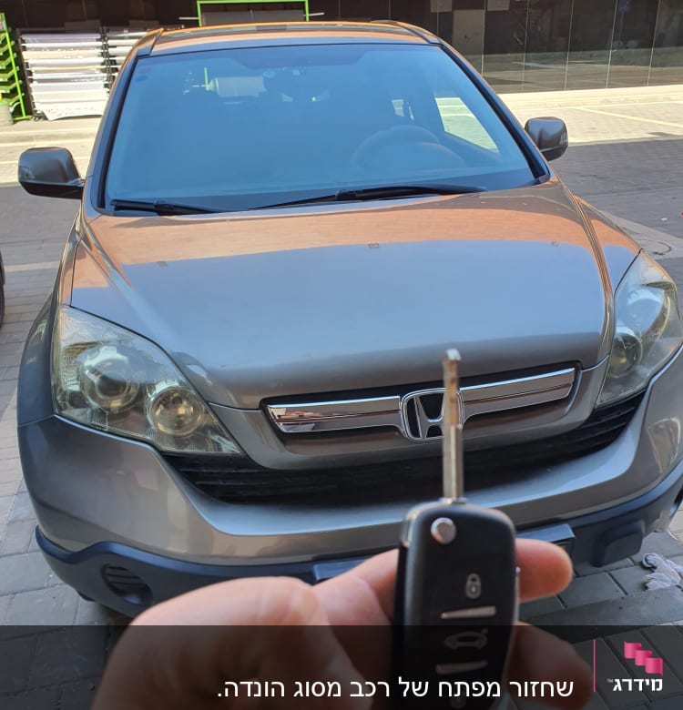 מפתח רכב מול מכונית הונדה אפורה